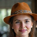 Ritratto di Anna Rossi, una donna sorridente di mezza età con capelli castani, che irradia salute e felicità.